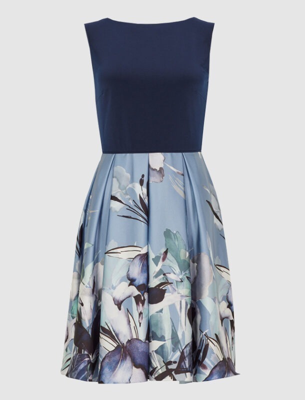 Ein ärmelloses Kleid mit einem blauen Oberteil und einem bedruckten Rock in blauen und grünen Blumenmustern. Ein ärmelloses Kleid mit einem blauen Oberteil und einem bedruckten Rock in blauen und grünen Blumenmustern.