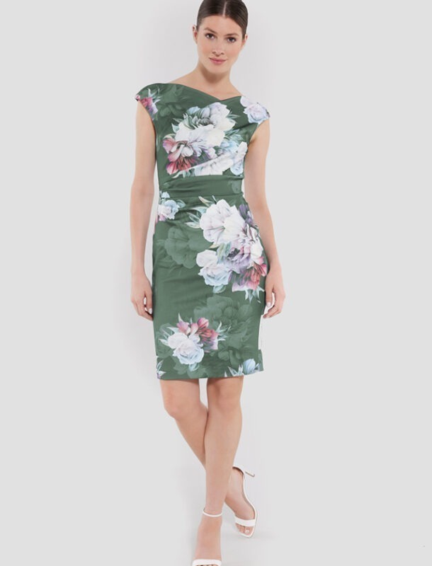 Eine Frau trägt ein blumiges, grünes Kleid mit einem schmalen Schnitt und kurzen Ärmeln. Eine Frau trägt ein blumiges, grünes Kleid mit einem schmalen Schnitt und kurzen Ärmeln.