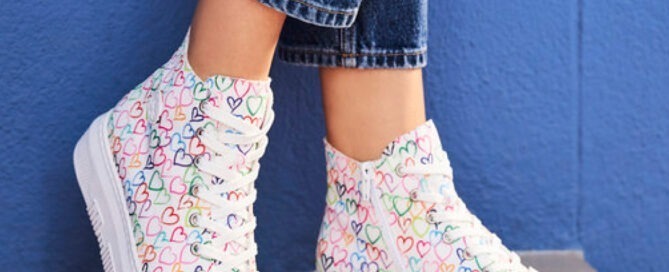 Bunte Sneakers mit Herzmotiv, kombiniert mit Jeans.