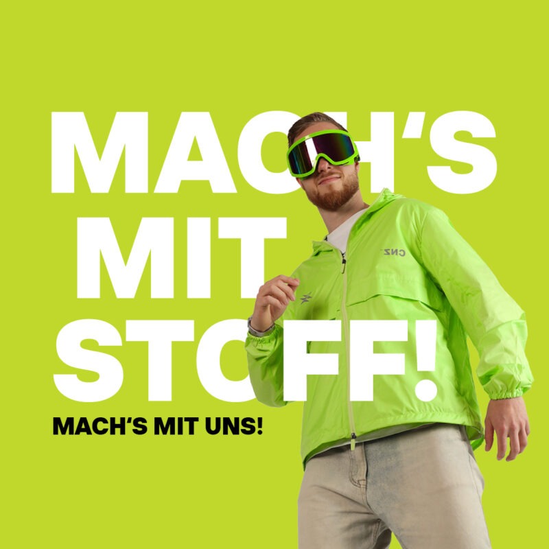 Ein Mann in einer leuchtend grünen Jacke trägt eine Skibrille vor einem grünen Hintergrund. Der Text "MACH'S MIT STOFF!" und "MACH'S MIT UNS!" ist prominent platziert.