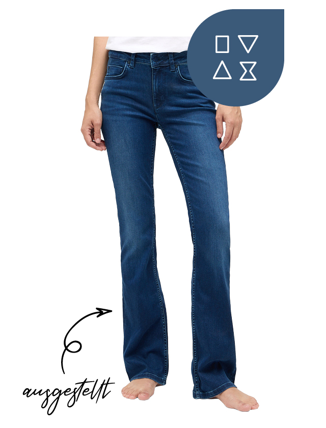 Eine Frau trägt eine blaue Bootcut-Jeans mit ausgestelltem Bein und ein weißes T-Shirt. Eine Frau trägt eine blaue Bootcut-Jeans mit ausgestelltem Bein und ein weißes T-Shirt.