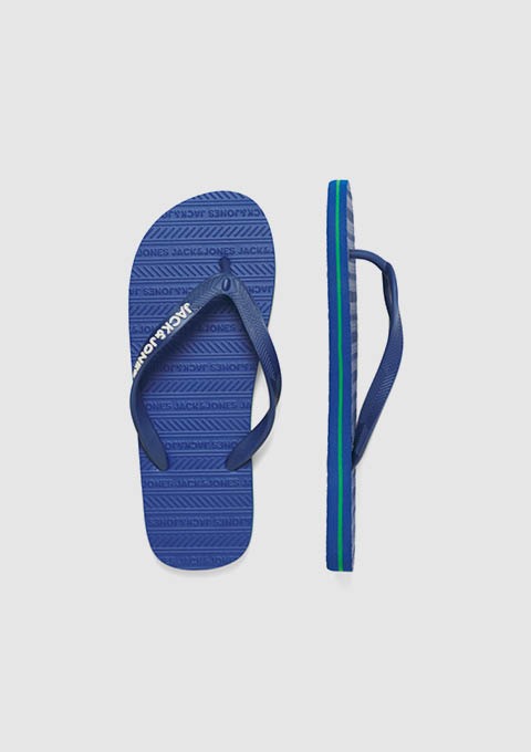 Zwei Flip-Flops mit blauen und grünen Riemen liegen nebeneinander. Zwei Flip-Flops mit blauen und grünen Riemen liegen nebeneinander.