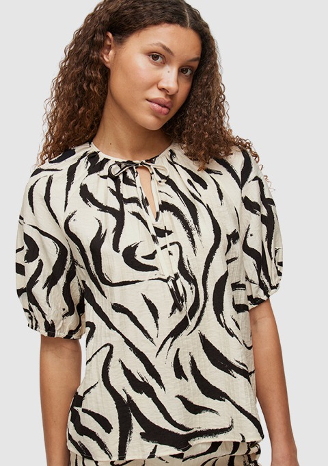 Eine Bluse mit Zebra-Print in Schwarz und Weiß wird von dem Modell getragen. Eine Bluse mit Zebra-Print in Schwarz und Weiß wird von dem Modell getragen.