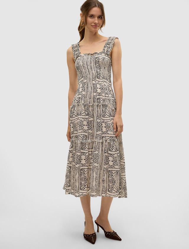 Das Kleid besteht aus einem gemusterten Stoff, der lebendige Farben und ein einzigartiges Design zeigt. Das Kleid besteht aus einem gemusterten Stoff, der lebendige Farben und ein einzigartiges Design zeigt.