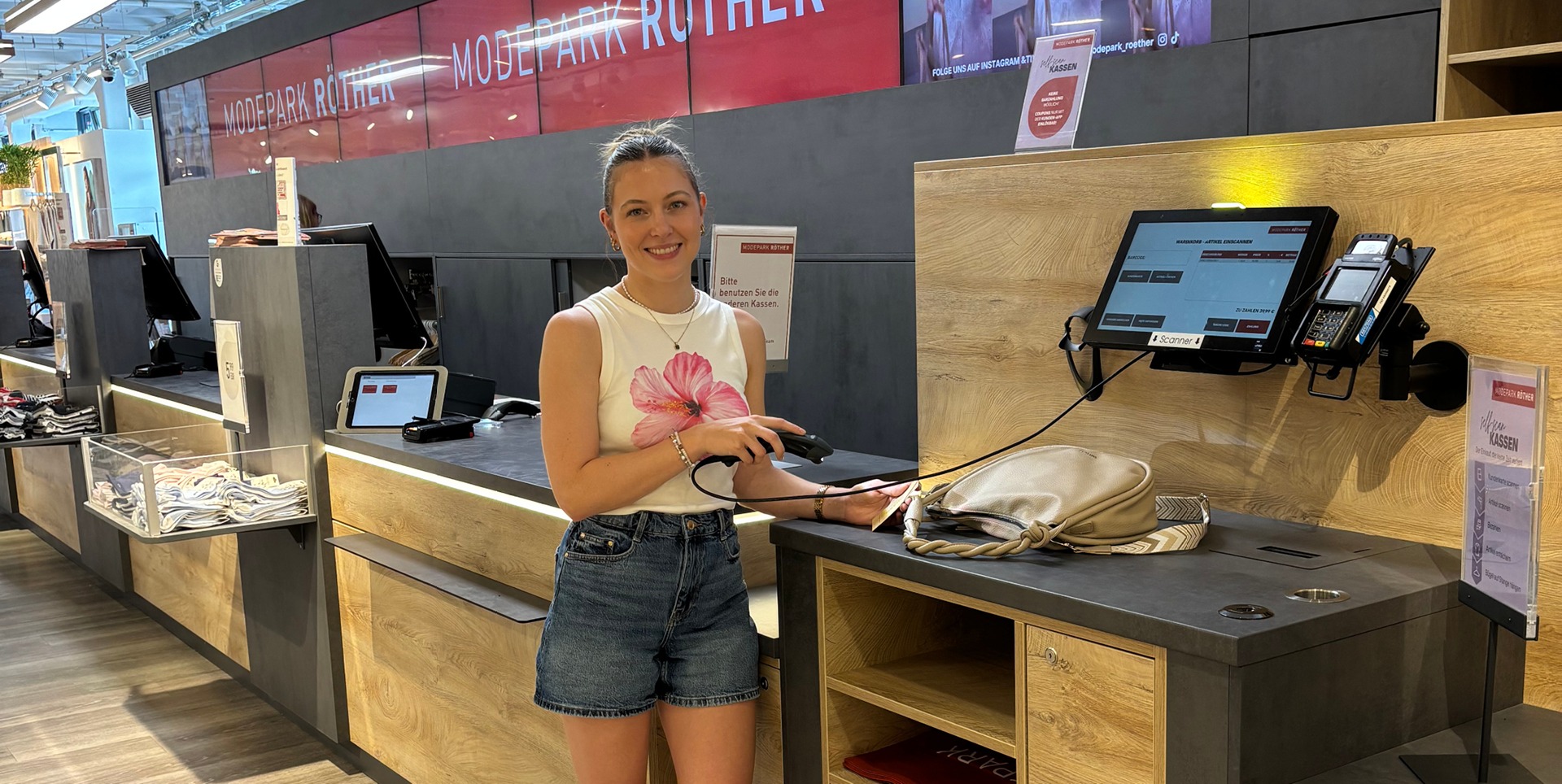 Projektleiterin, Julia Kalyciok, an der Self-Checkout-Kasse in der MODEOARK RÖTHER Filiale in Michelfeld. Projektleiterin, Julia Kalyciok, an der Self-Checkout-Kasse in der MODEOARK RÖTHER Filiale in Michelfeld.