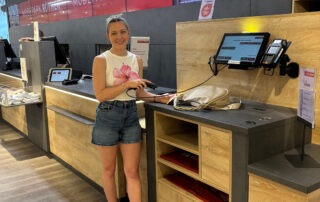 Projektleiterin, Julia Kalyciok, an der Self-Checkout-Kasse in der MODEOARK RÖTHER Filiale in Michelfeld.