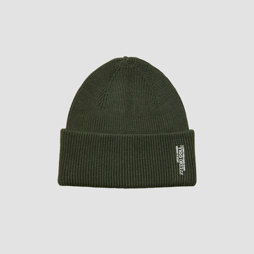 Dunkelgrüne Strickmütze mit Umschlag und kleinem rechteckigem Stoffetikett mit weißer Aufschrift.