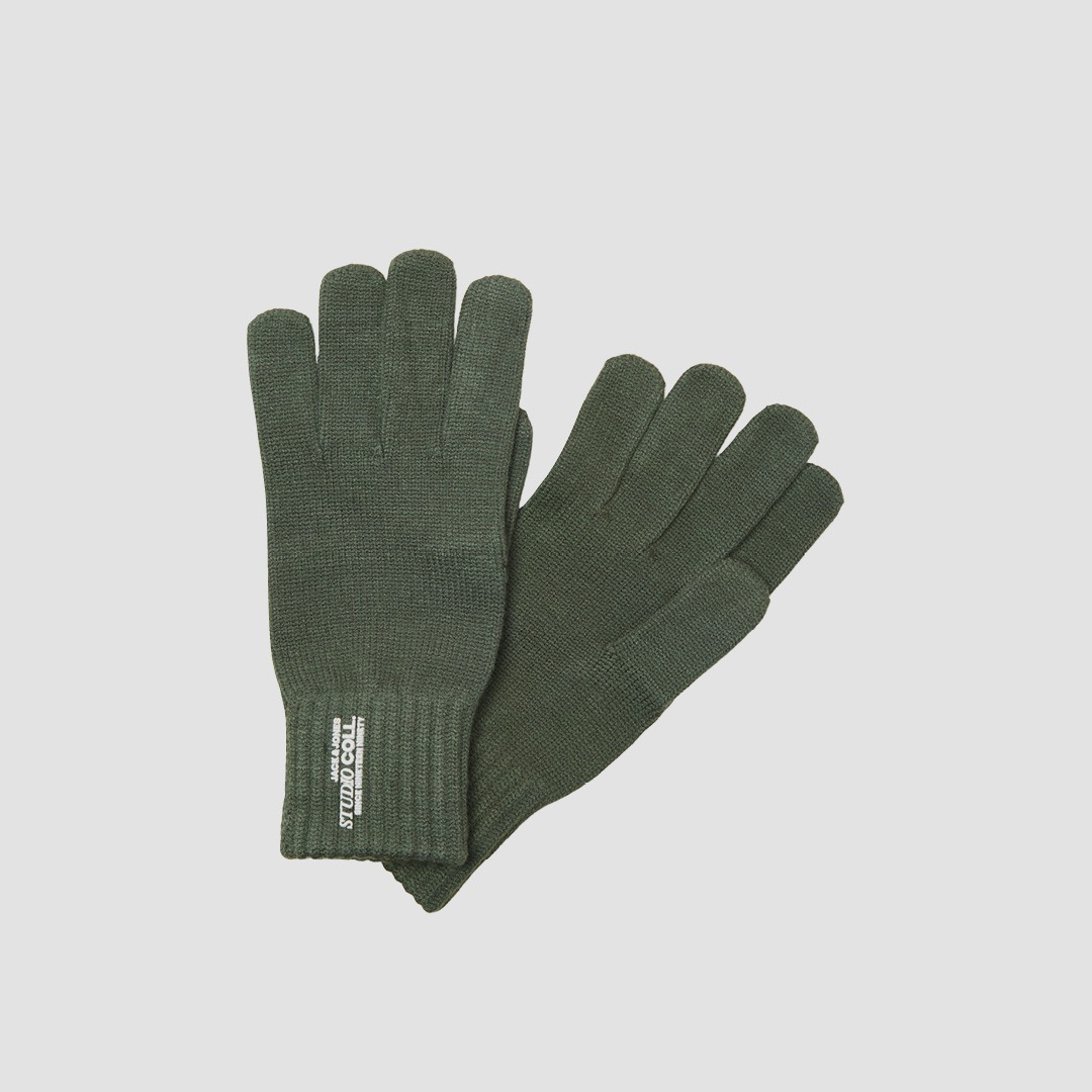 Dunkelgrüne Strickhandschuhe mit Bündchen und weißem Textlabel am Handgelenk.