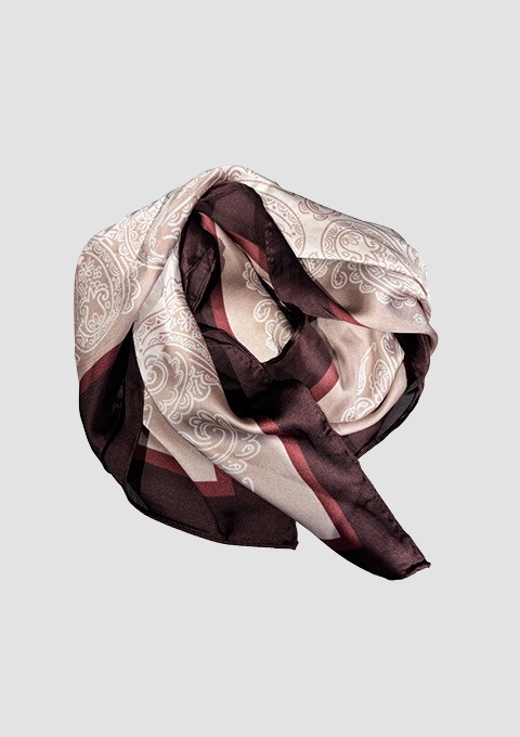 Seidiger Schal mit Paisley-Muster in Beige, Dunkelbraun und Rosatönen, locker zusammengelegt.