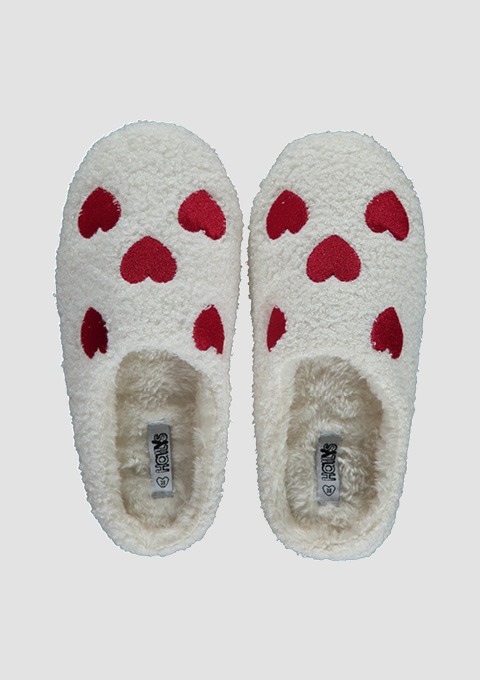 Weiche weiße Hausschuhe mit rotem Herzmuster und flauschigem Innenfutter, von oben fotografiert.