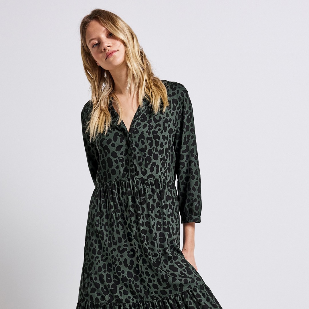 Das Modell trägt ein grünes Kleid mit Leomuster.