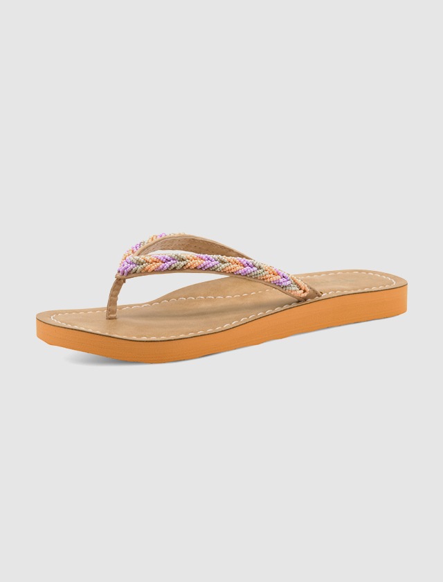 Flip-Flop mit geflochtenem Band in lila, orange und gelb, auf einem braunen und orangefarbenen Fußbett. Flip-Flop mit geflochtenem Band in lila, orange und gelb, auf einem braunen und orangefarbenen Fußbett.